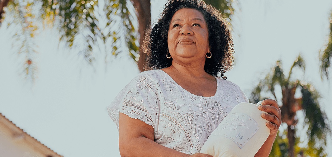 Mulher segurando instrumento para fazer renda em um dia de sol