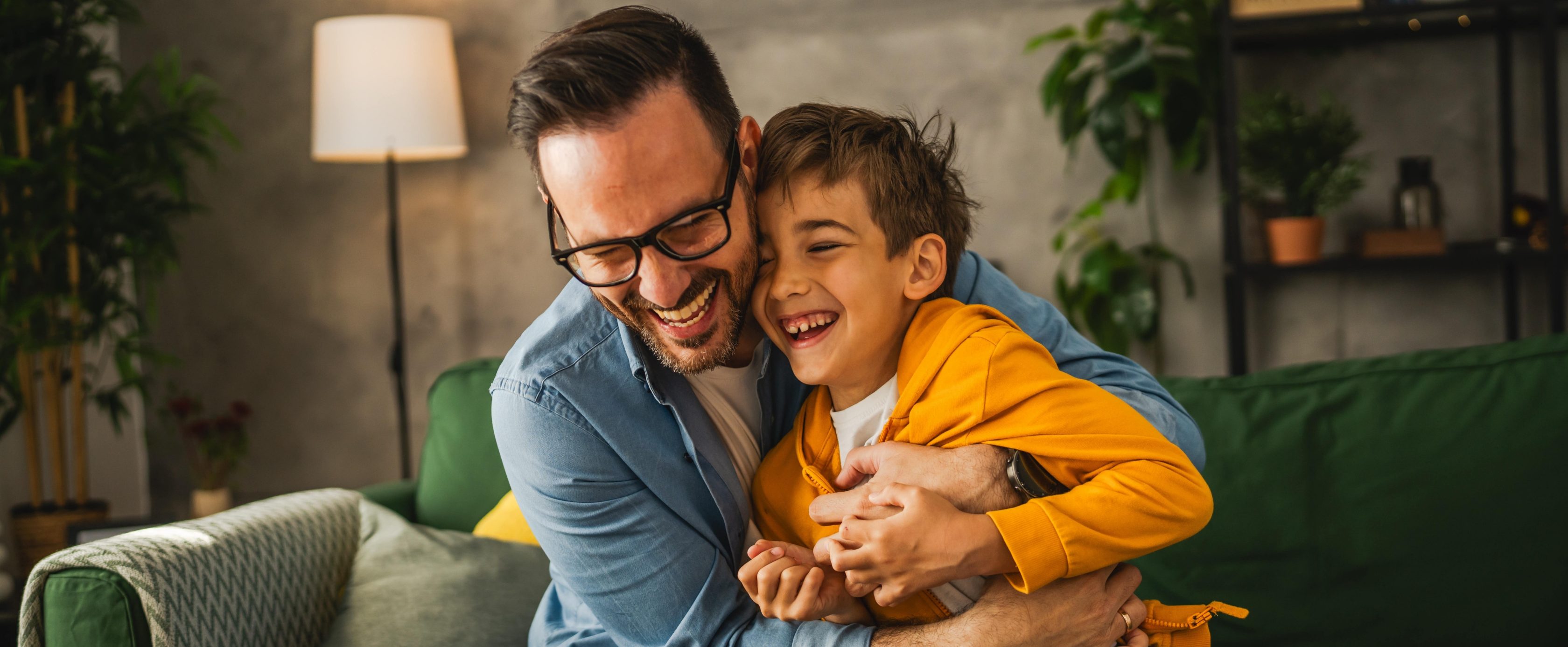 Pai e filho felizes reunidos em um abraço na sala de casa
