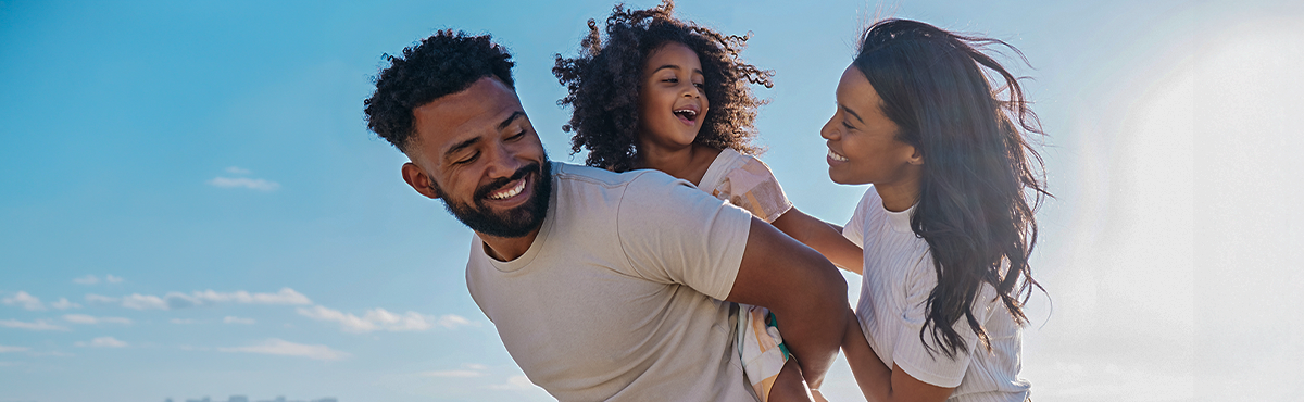 Família feliz com homem segurando criança no colo 