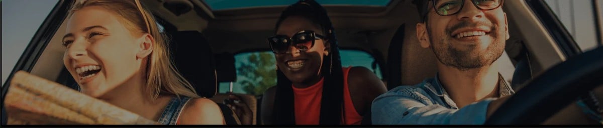 Três pessoas sorrindo no carro