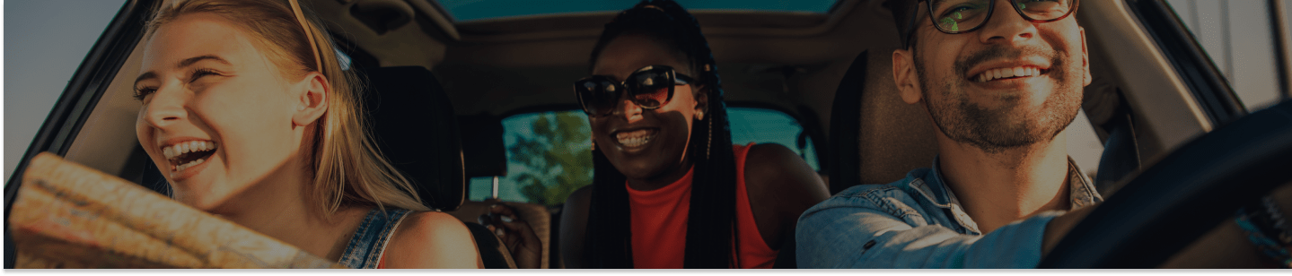 Três pessoas sorrindo no carro