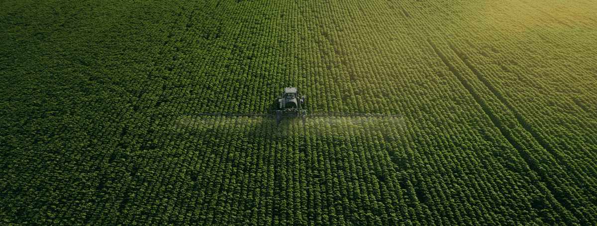 Imagem aérea de uma fazenda com uma colheitadeira na plantação