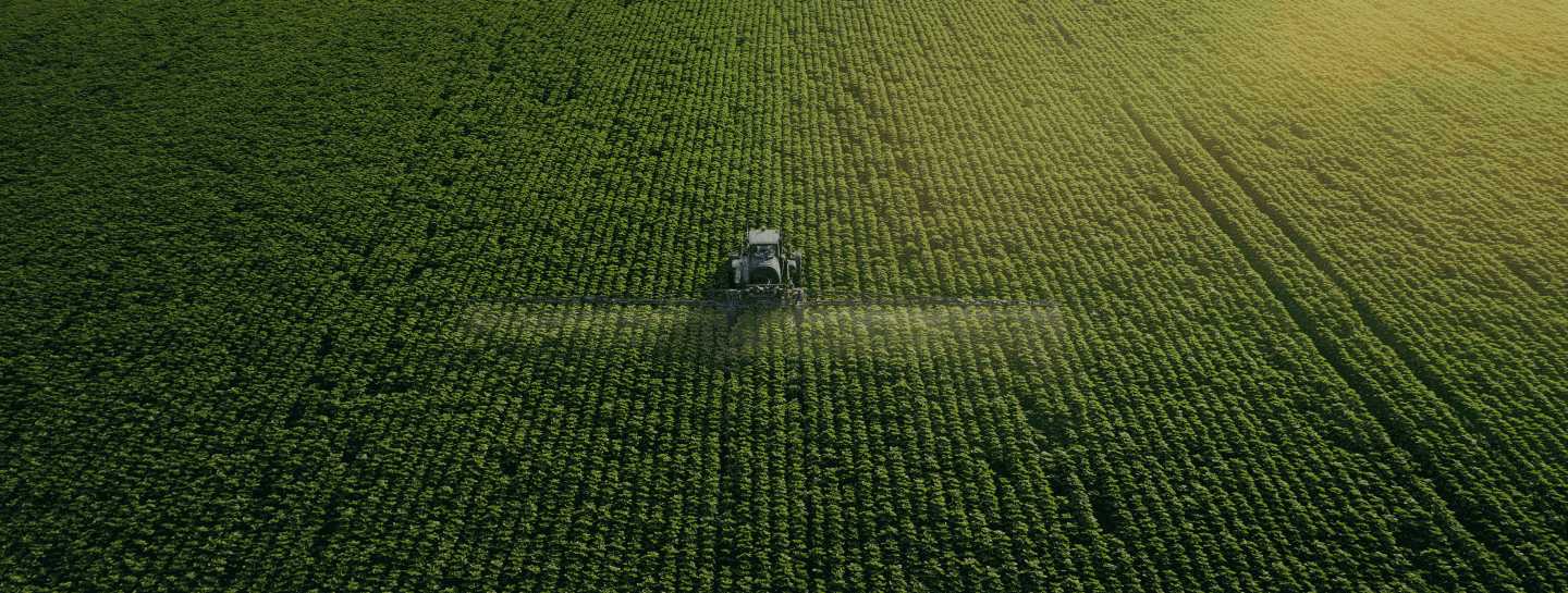 Imagem aérea de uma fazenda com uma colheitadeira na plantação