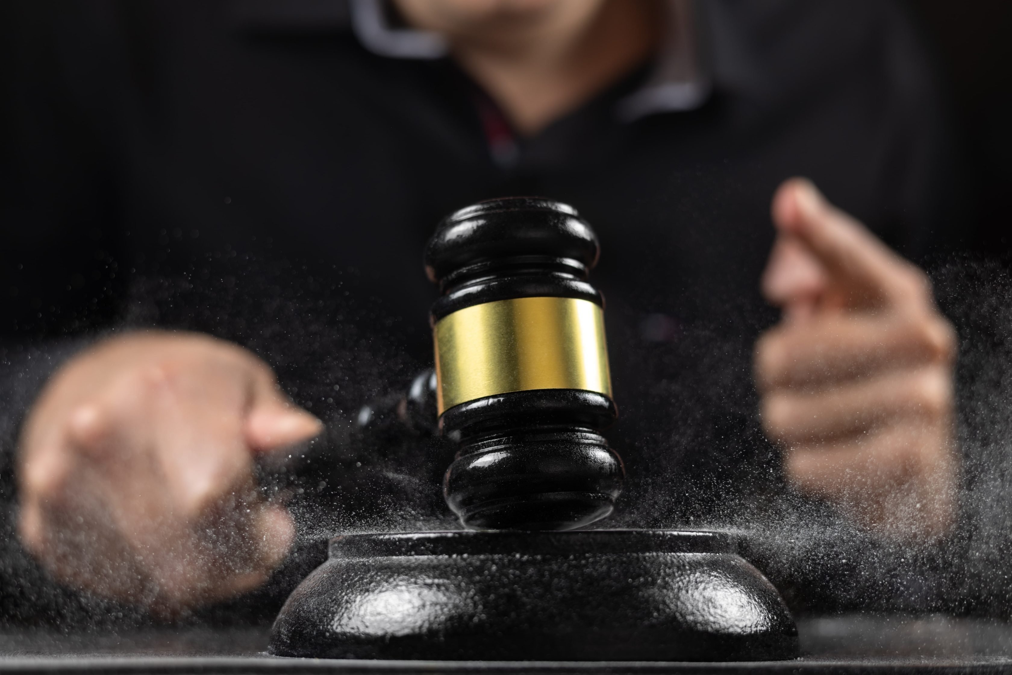 Um martelo de juiz sendo batido. A imagem representa uma cena típica de um tribunal