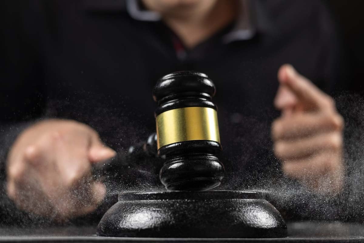 Um martelo de juiz sendo batido. A imagem representa uma cena típica de um tribunal