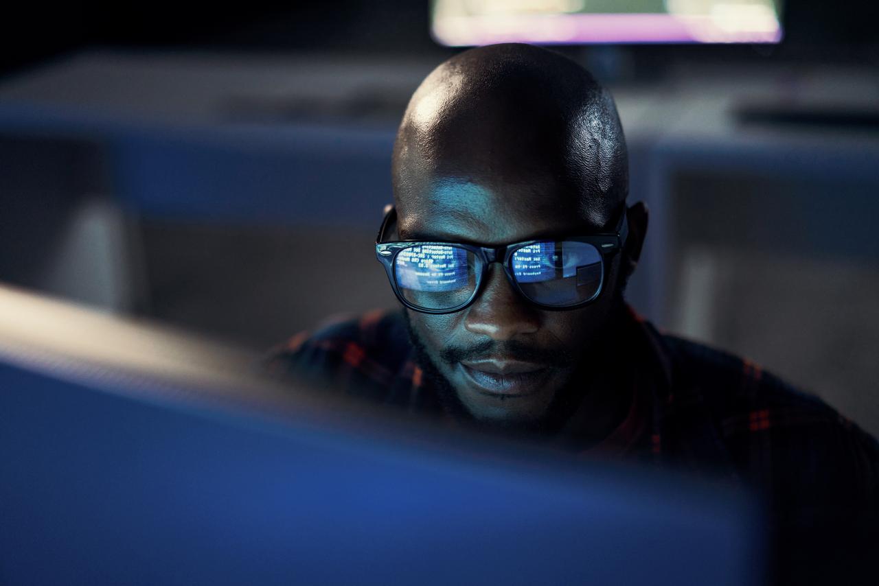 Homem analisando códigos em seu computador