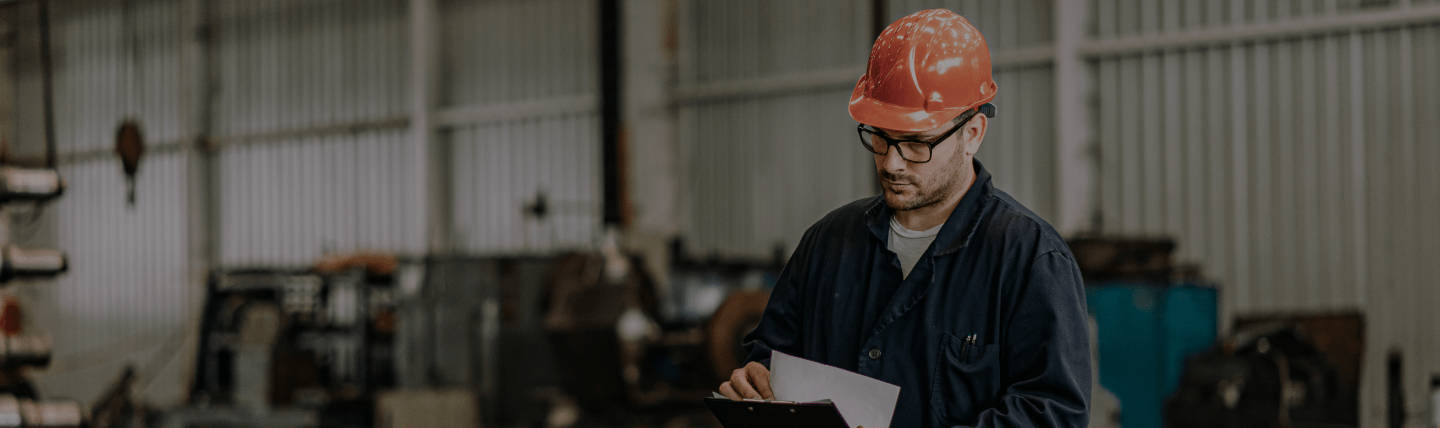 Engenheiro analisando documentos em ambiente de construção.