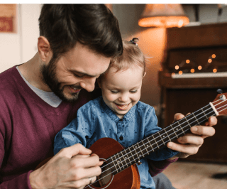 Pai tocando instrumento musical com a filha pequena