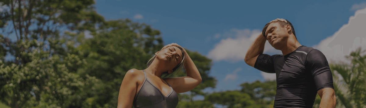 Homem e mulher fazendo alongamento em um parque
