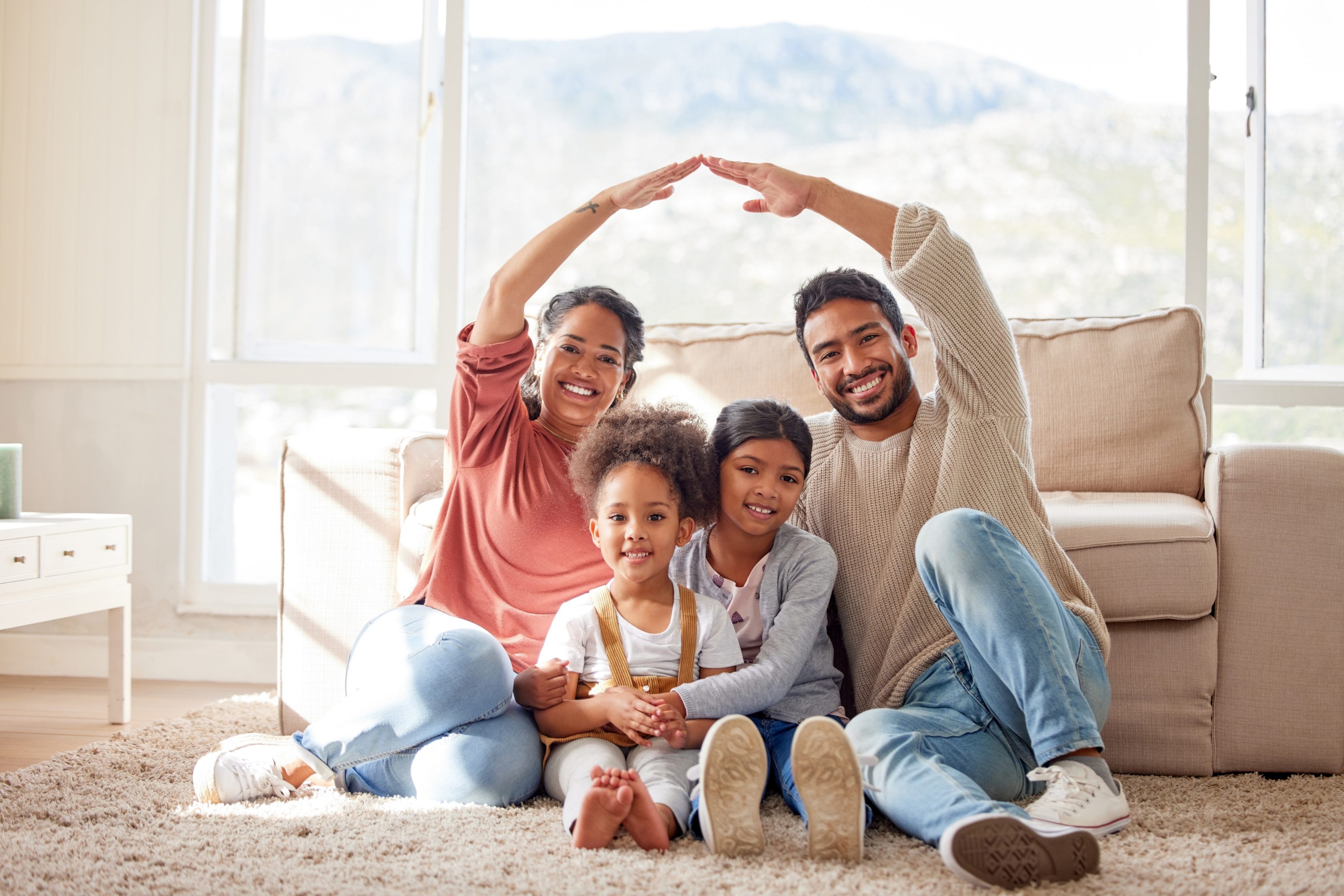 Familia feliz sentados em frente ao sofá