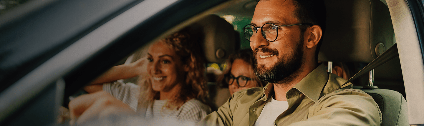 Família sorrindo dentro do carro