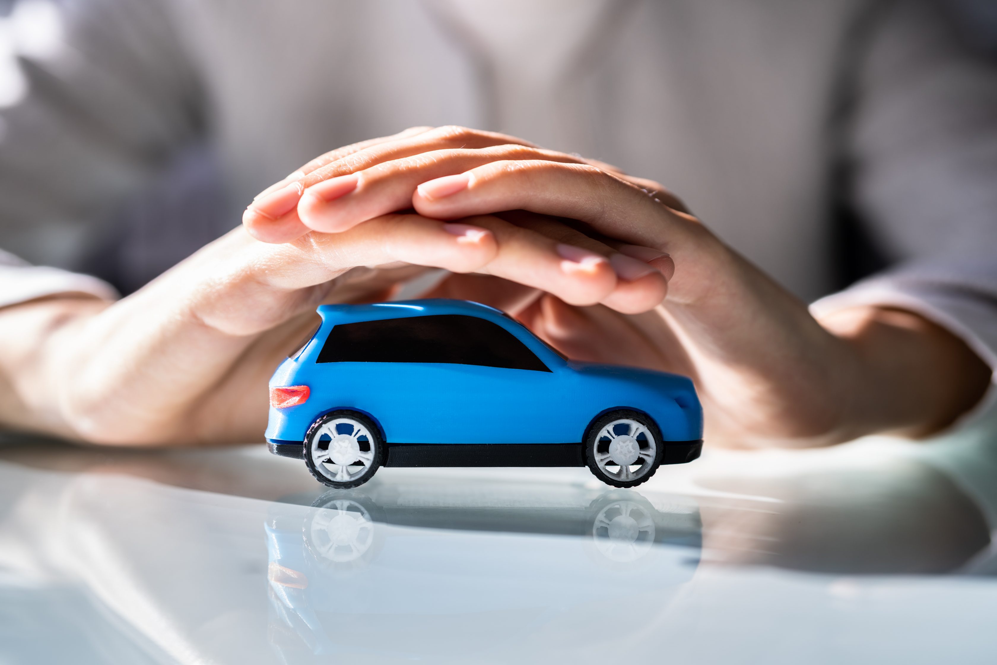 Imagem de duas mãos sobre um carro de brinquedo para ilustrar a parte que fala como a tabela fipe funciona na prática
