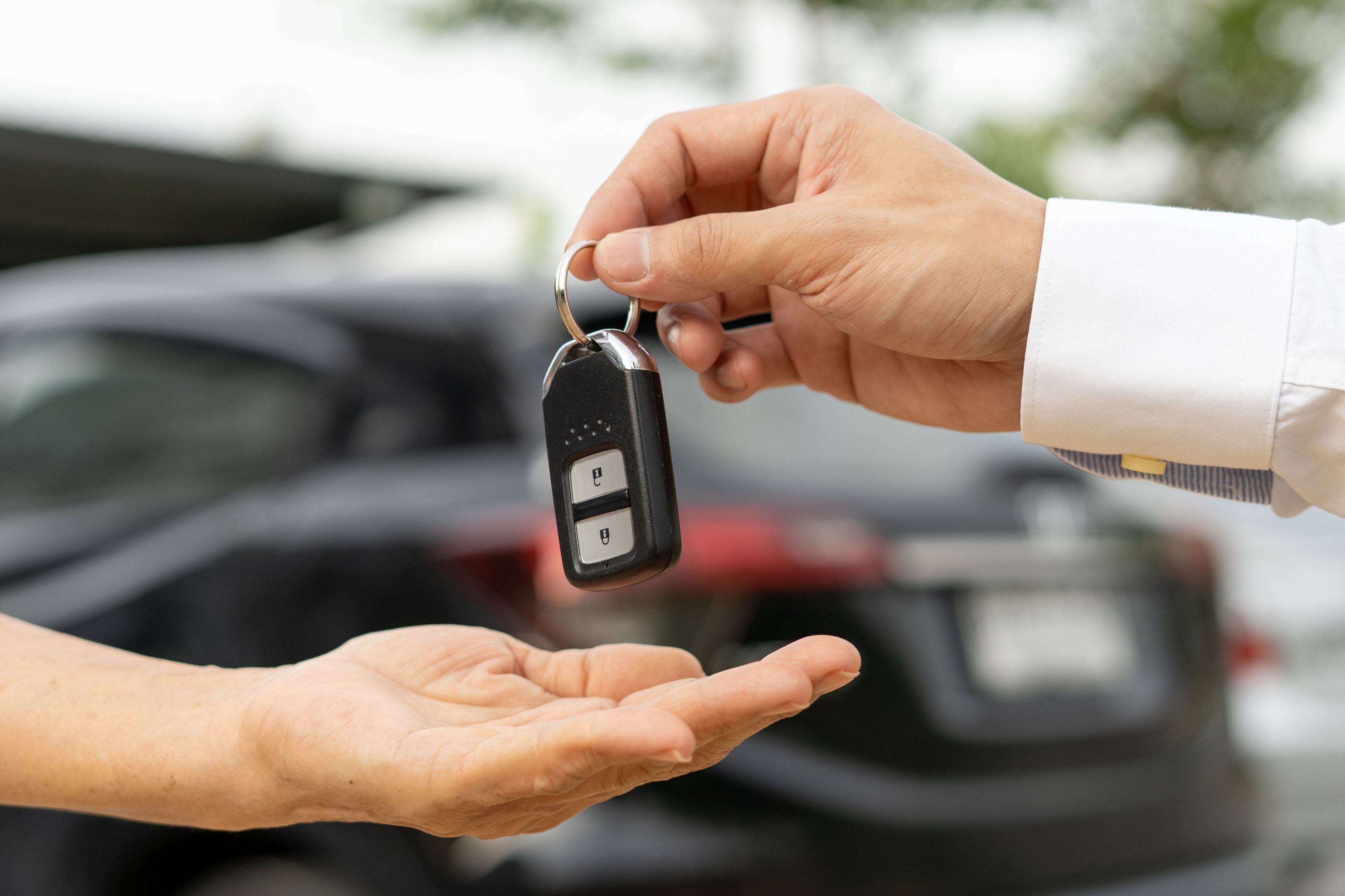 Imagem de uma chave de carro sendo entregue para outra pessoa dentro da aba "Transferência de veículo"