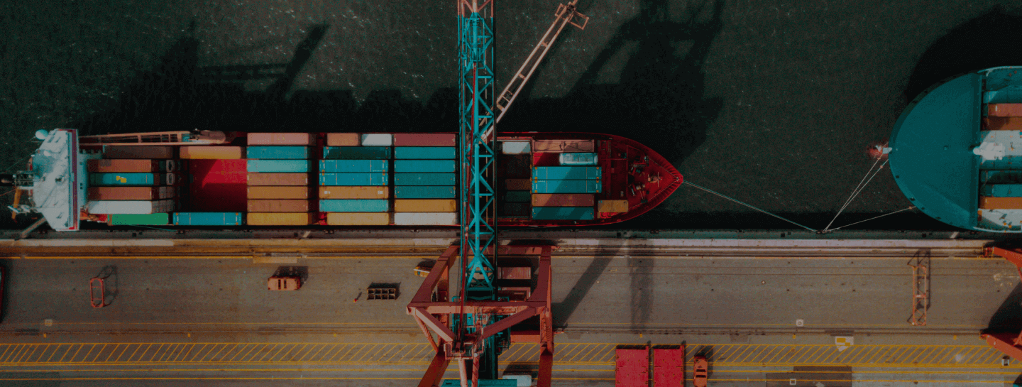 Imagem de uma infraestrutura portuária com navios para ilustrar o banner da seção "Transportes"
