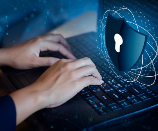 Imagem de uma pessoa utilizando o notebook e um ícone de segurança