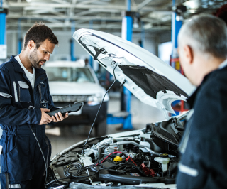 Imagem de mecânicos da Allianz realizando um diagnóstico em um veículo