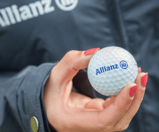 Imagem de uma mulher segurando uma bola de golf com o logo da Allianz