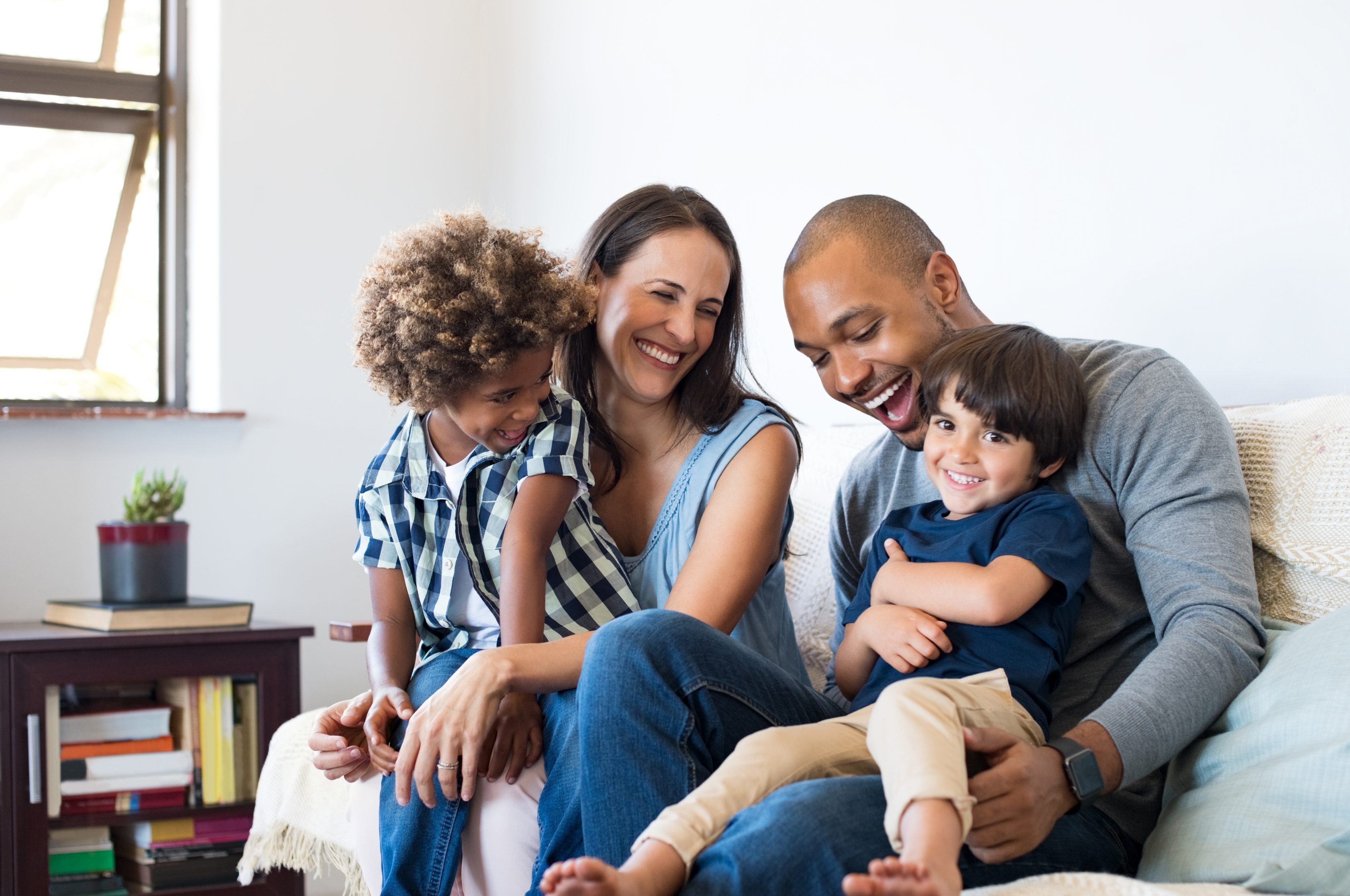 Imagem de uma família sentados no sofá sorrindo