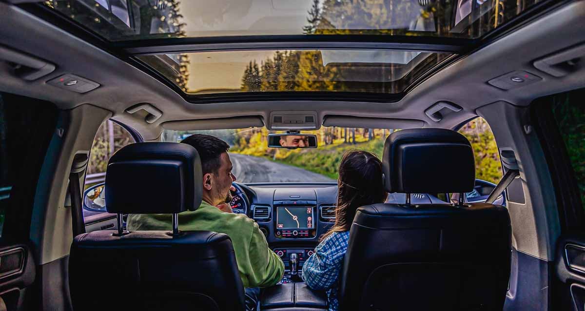 Imagem de um casal conversando dentro do seu automóvel