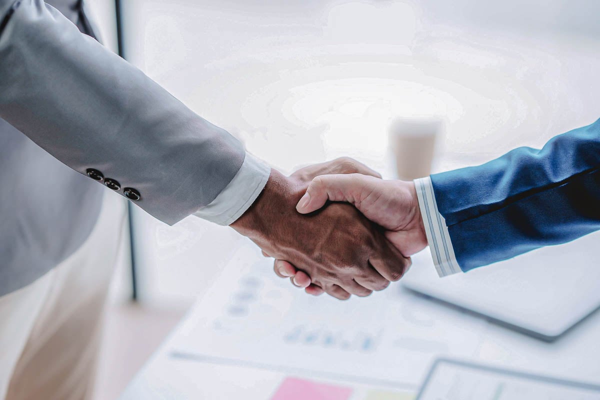 Imagem de corretores da Allianz apertando as mãos