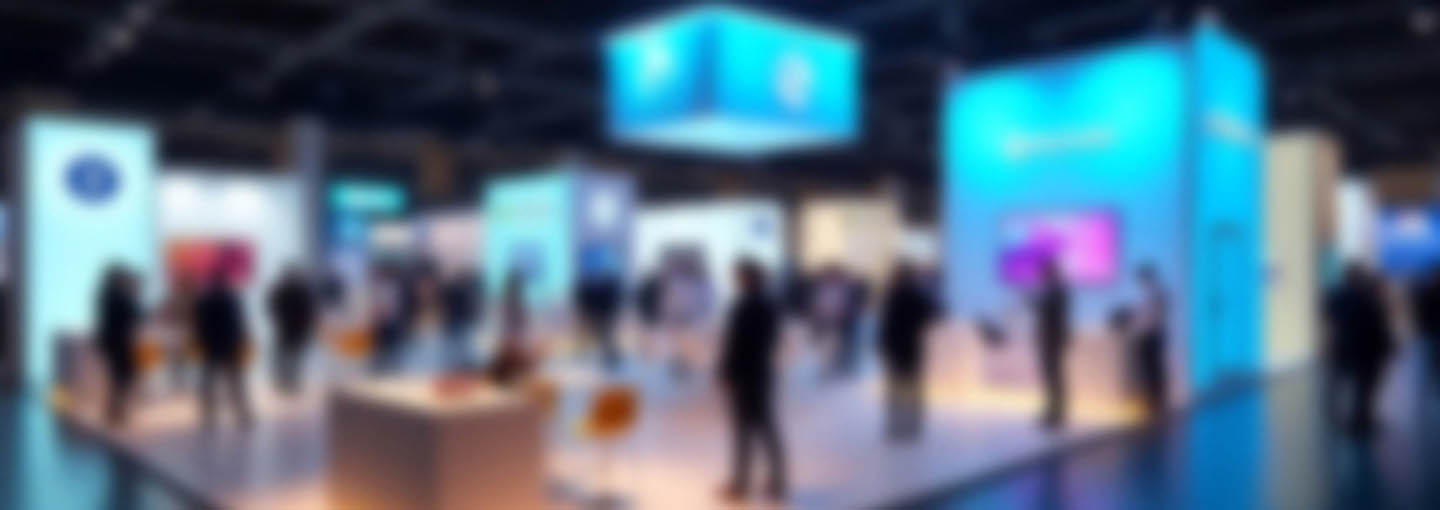 Estandes iluminados em feira de tecnologia com pessoas circulando em ambiente corporativo
