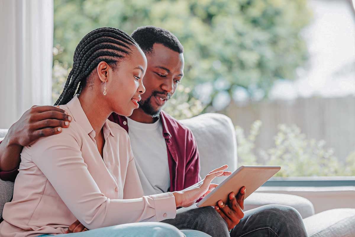 Imagem de um casal utlizando um tablet