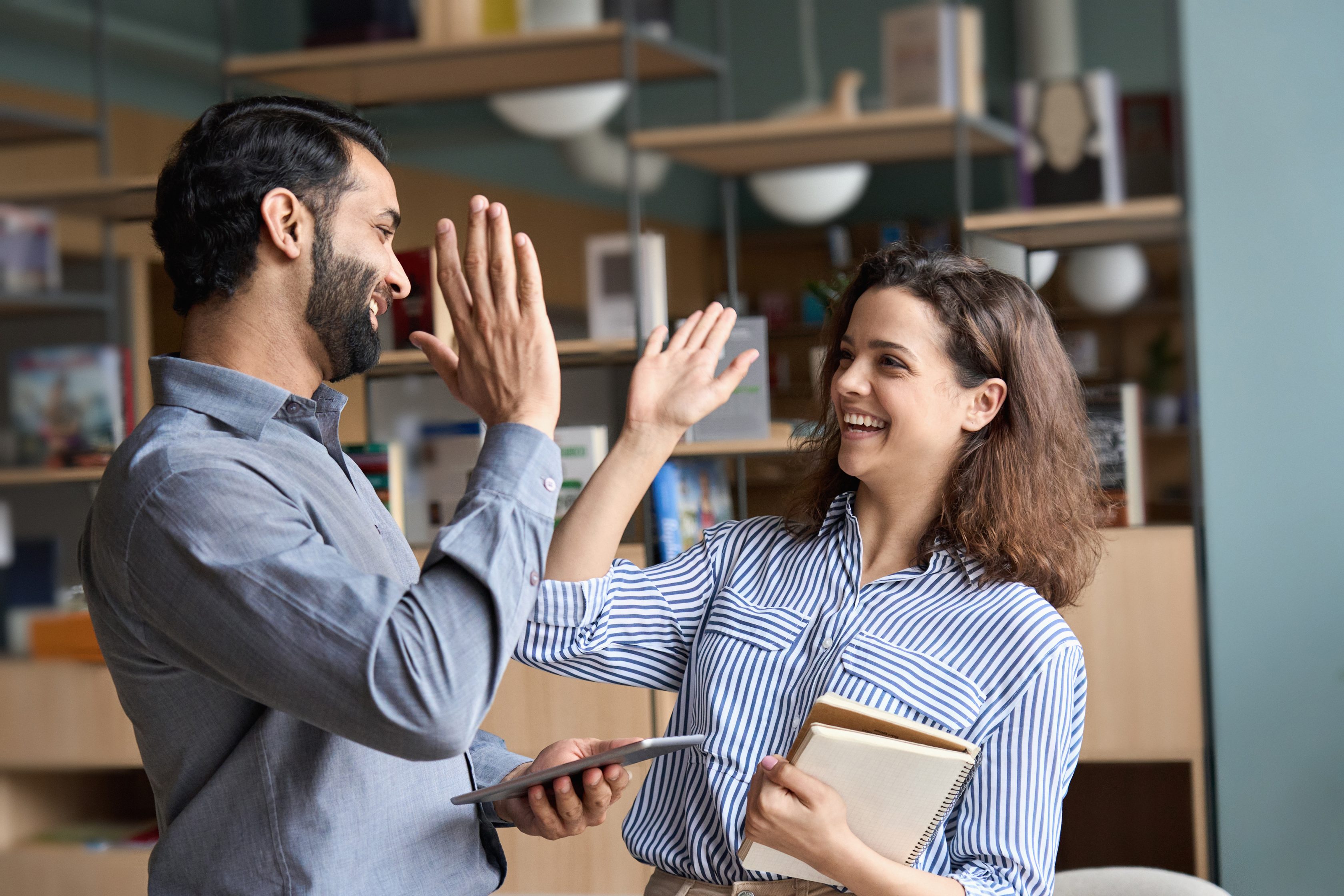 Corretores da Allianz comemorando e batendo as mãos