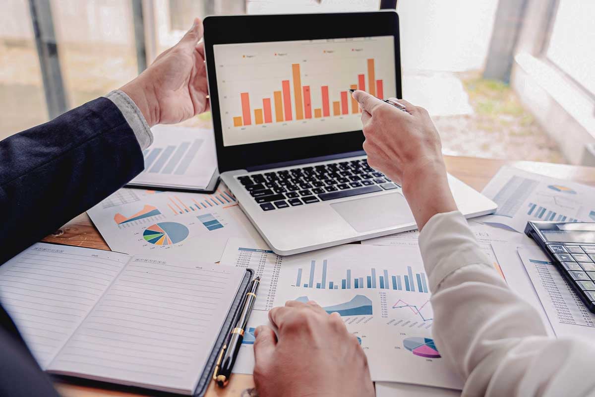 Executivos da Allianz fazendo análises de dados pelo notebook