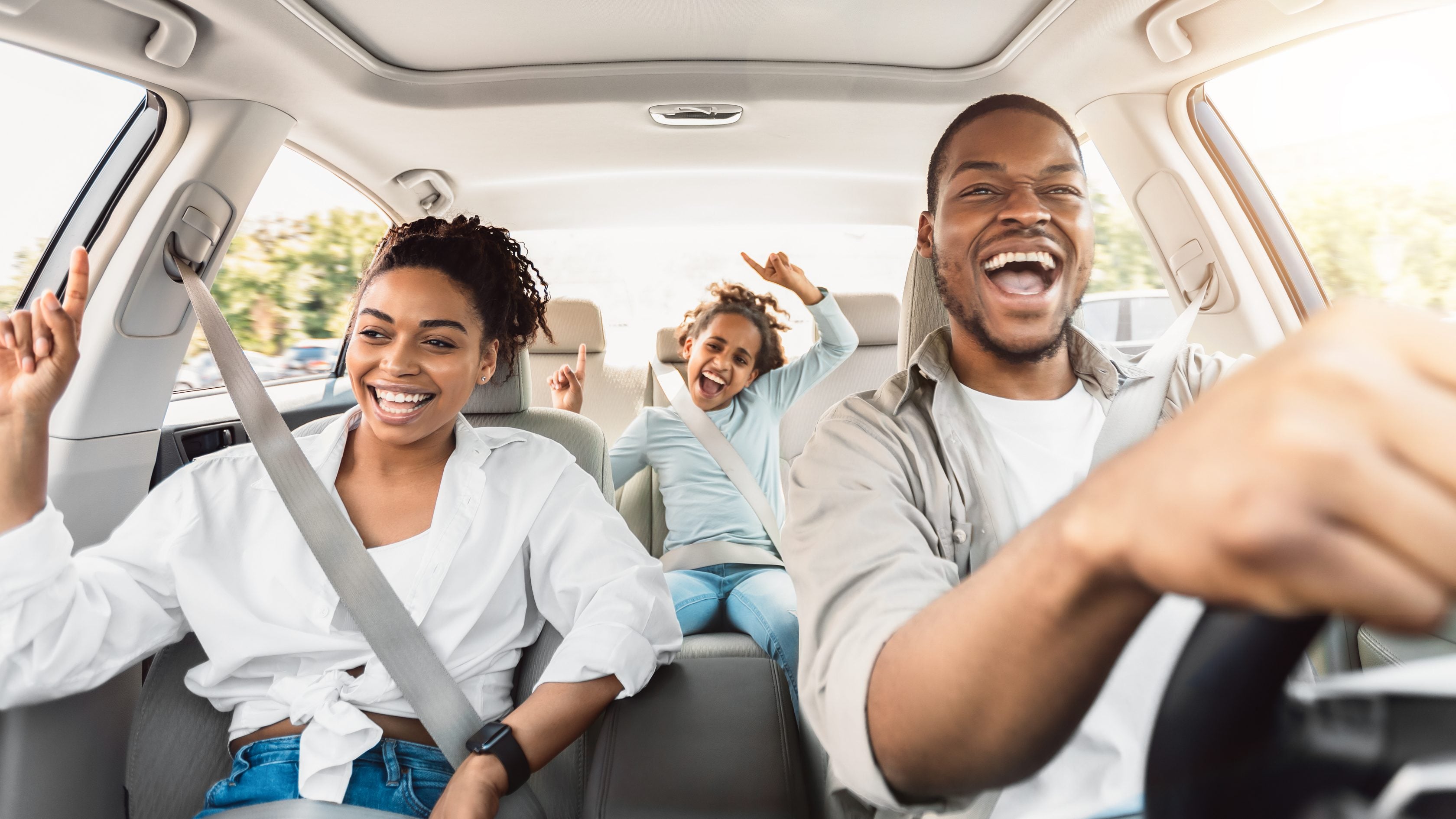 Imagem de uma família dentro do seu automóvel sorrindo