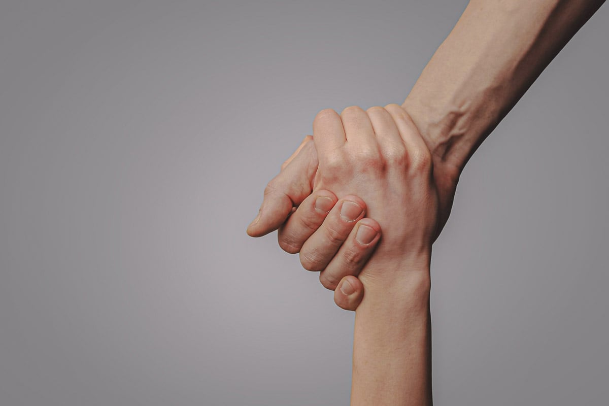 Imagem duas pessoas apertando as mãos 