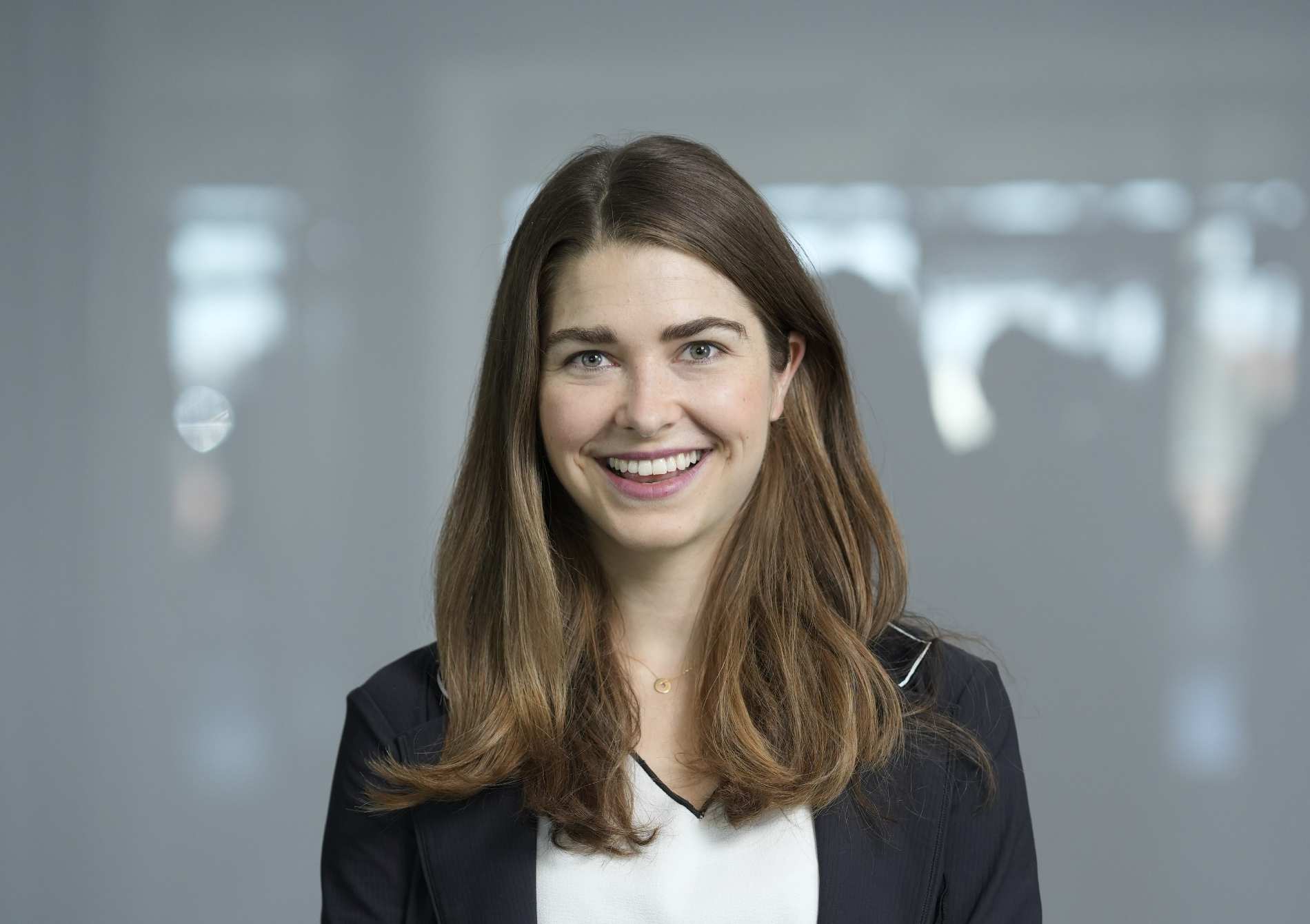 Pessoa em ambiente corporativo, posicionada à frente de fundo neutro, representando liderança e participação da Allianz em debates sobre sustentabilidade.