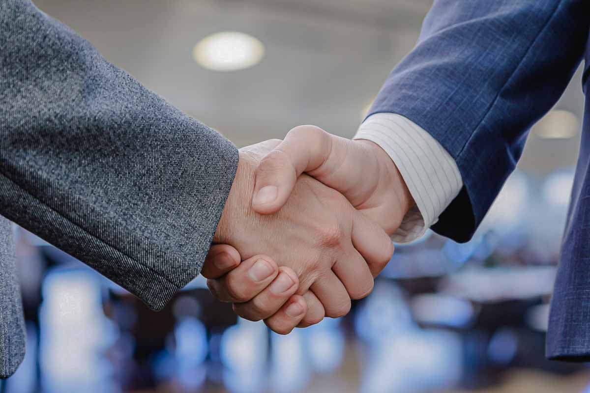 Executivos da Allianz apertando as mãos em sinal de acordo de negócio