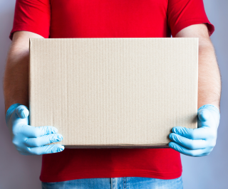 Homem segurando uma caixa de doações feitas para Allianz para comunidade em São Paulo