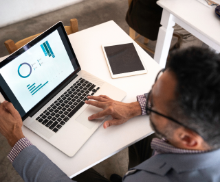 Executivo da Allianz fazendo análises de dados atráves do seu notebook