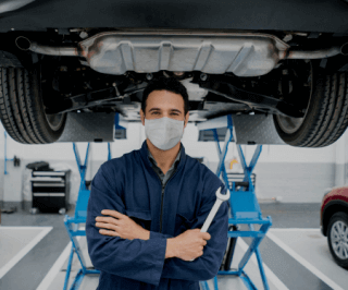 Mecânico segurando uma ferramenta embaixo de um automóvel