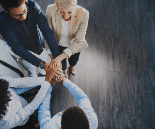 Equipe de colaboradores da Allianz colocando as mãos uma em cima da outra