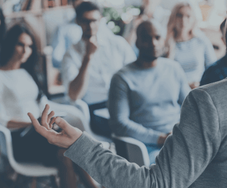 Imagem de pessoas em treinamento assistindo uma palestra 