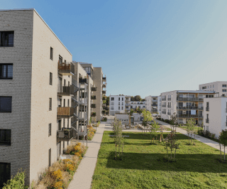 Imagem de um condomínio de prédios com uma área verde na frente