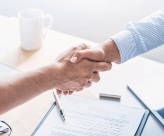 Homem e mulher apertando as mãos em sinal de fechamento de acordo