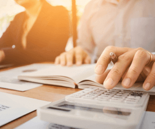 Homem fazendo cálculos e anotações em um caderno