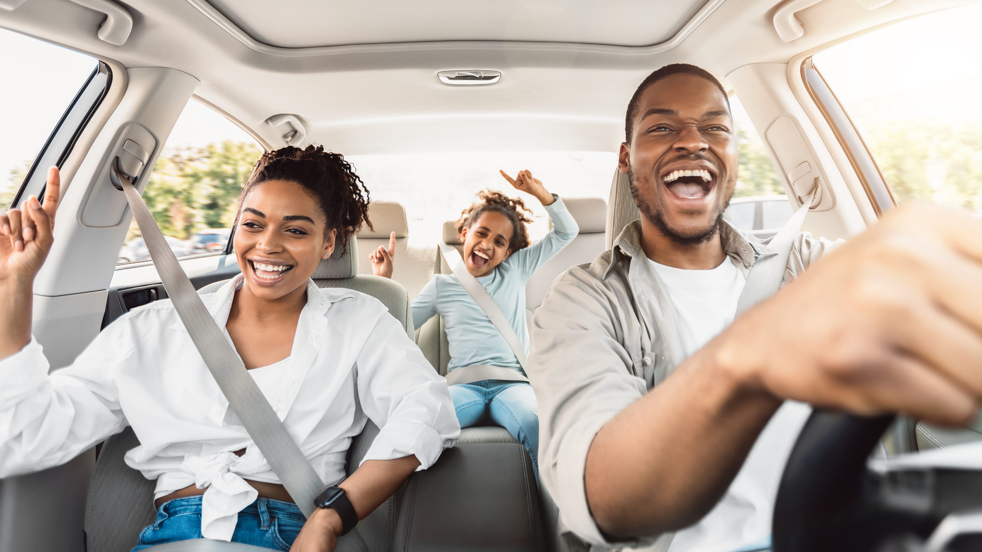 Família sorrindo dentro do carro
