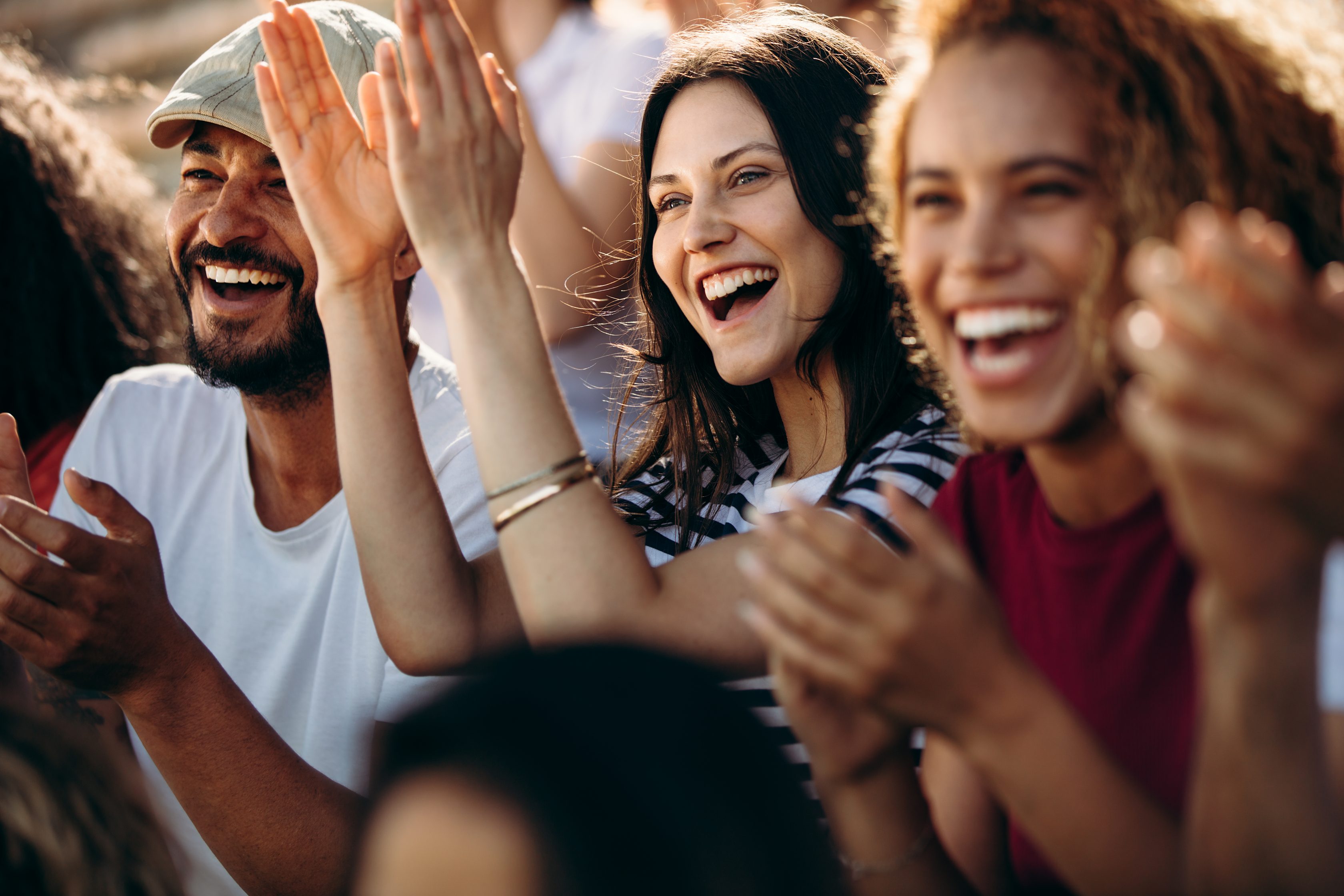 Imagens de pessoas aplaudindo e sorrindo em texto que fala que a Allianz concede 20% de desconto em show do Titãs