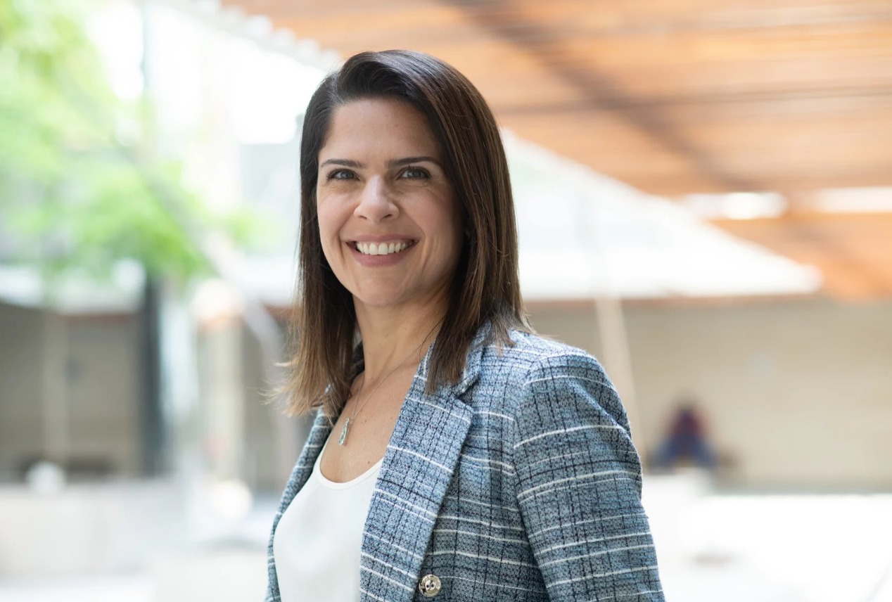 Mulher vestida socialmente e sorrindo
