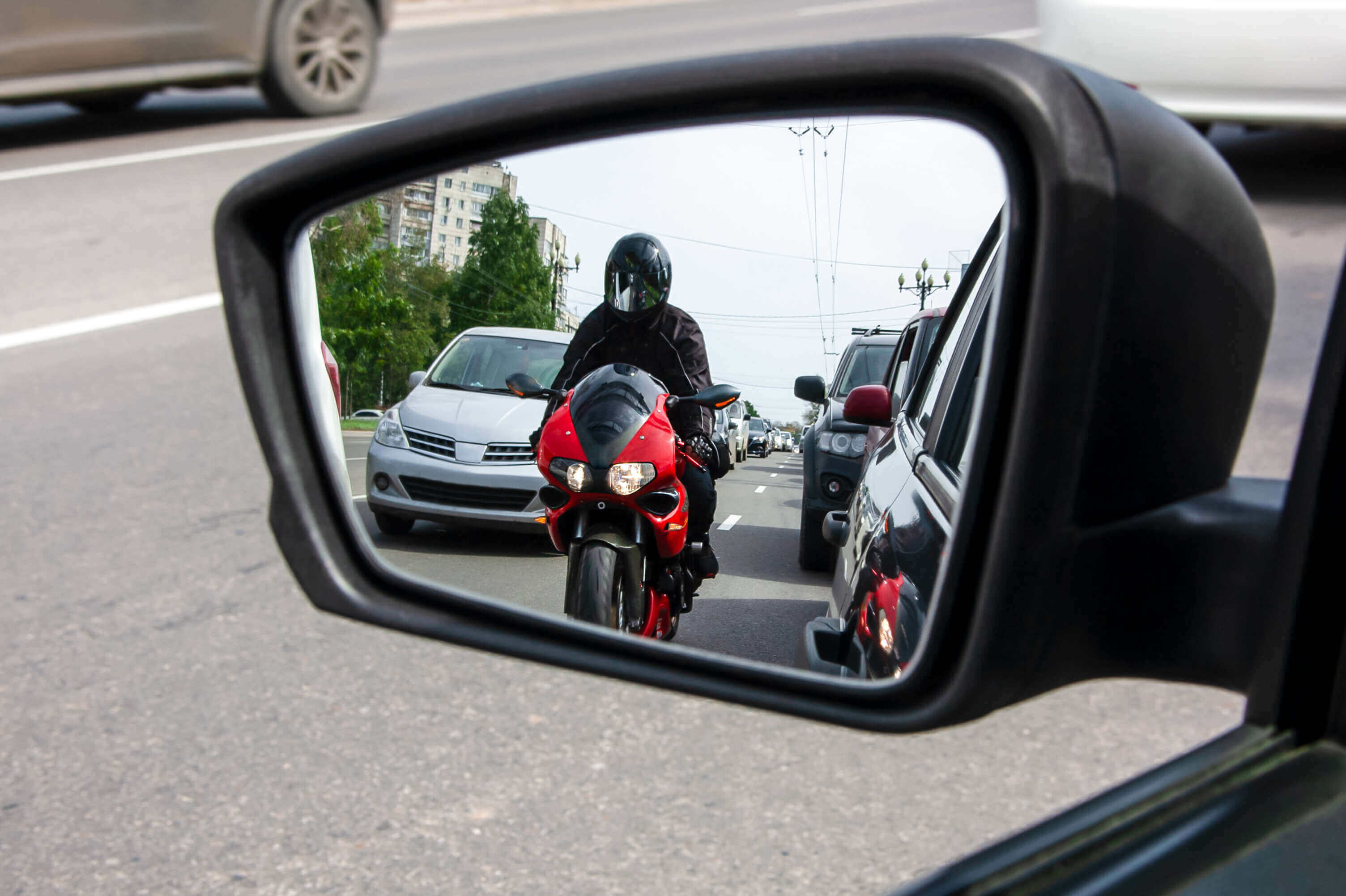 Retrovisor de carro visualizando um motociclista