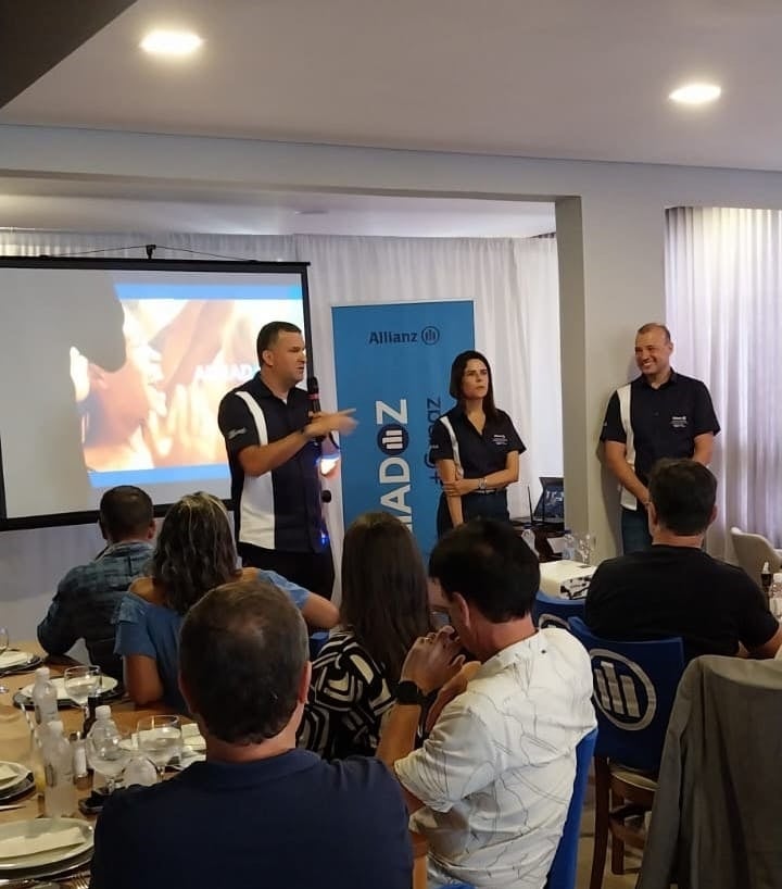 corretores assistindo apresentação do Alliadoz 2024 em evento.