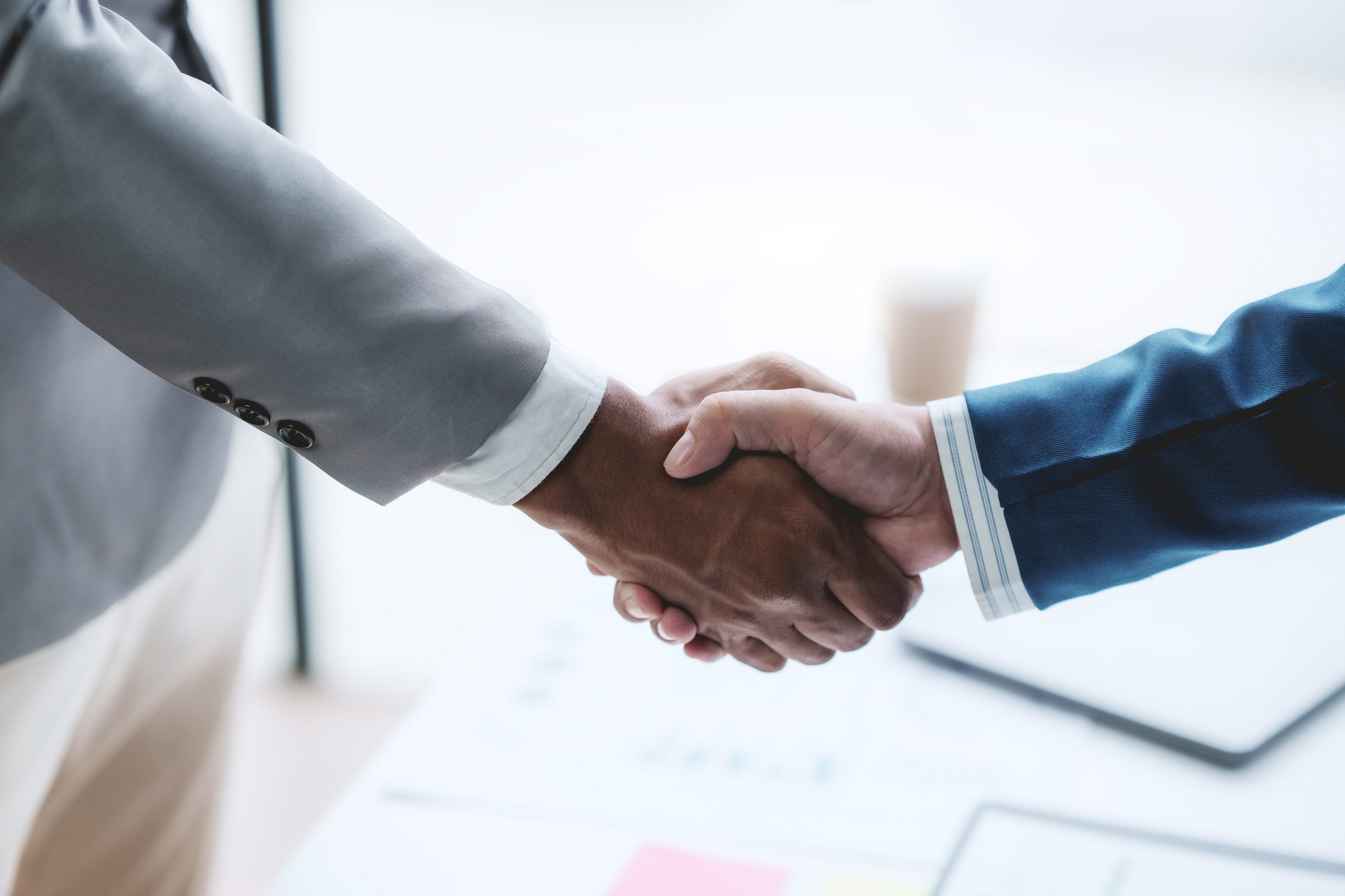 Close-up de aperto de mãos entre duas pessoas firmando negocio ou acordo.