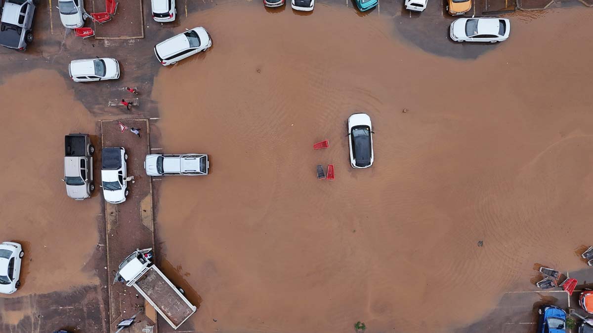 Vista aérea de estacionamento alagado superficialmente com carros.