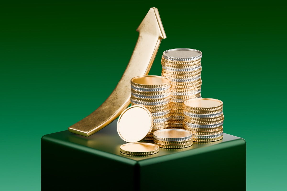 Moedas empilhadas com símbolos de setas para cima, indicando crescimento financeiro.