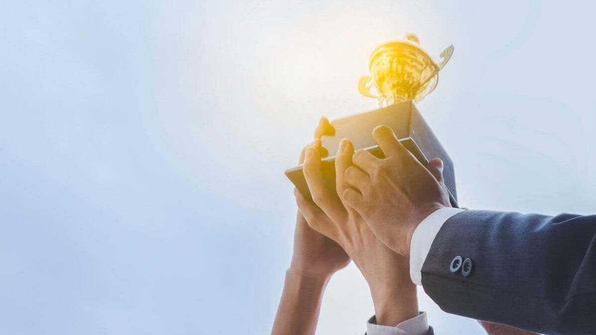 Troféu dourado em fundo verde representando conquista da Allianz  