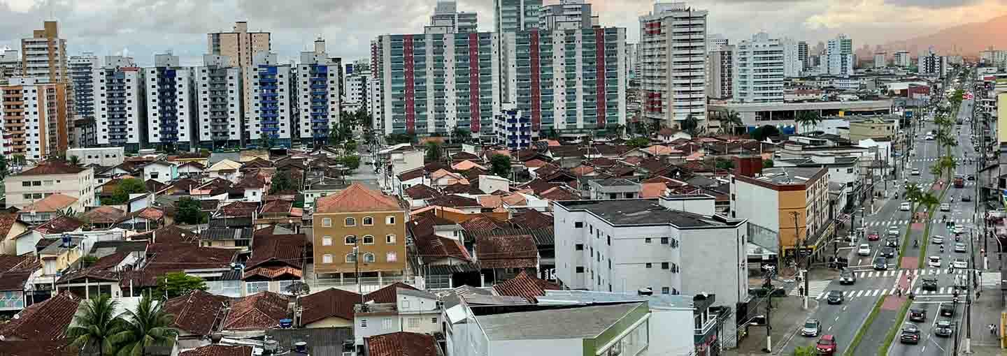 Vista urbana com prédios altos e avenida movimentada.